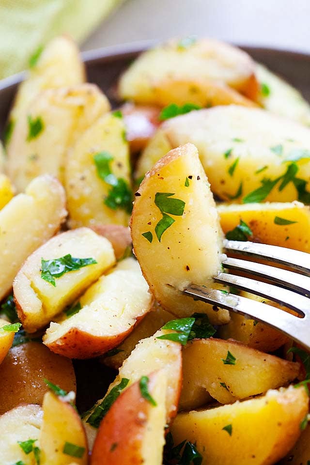Boiled potatoes with parsley, butter, salt and black pepper, ready to serve.