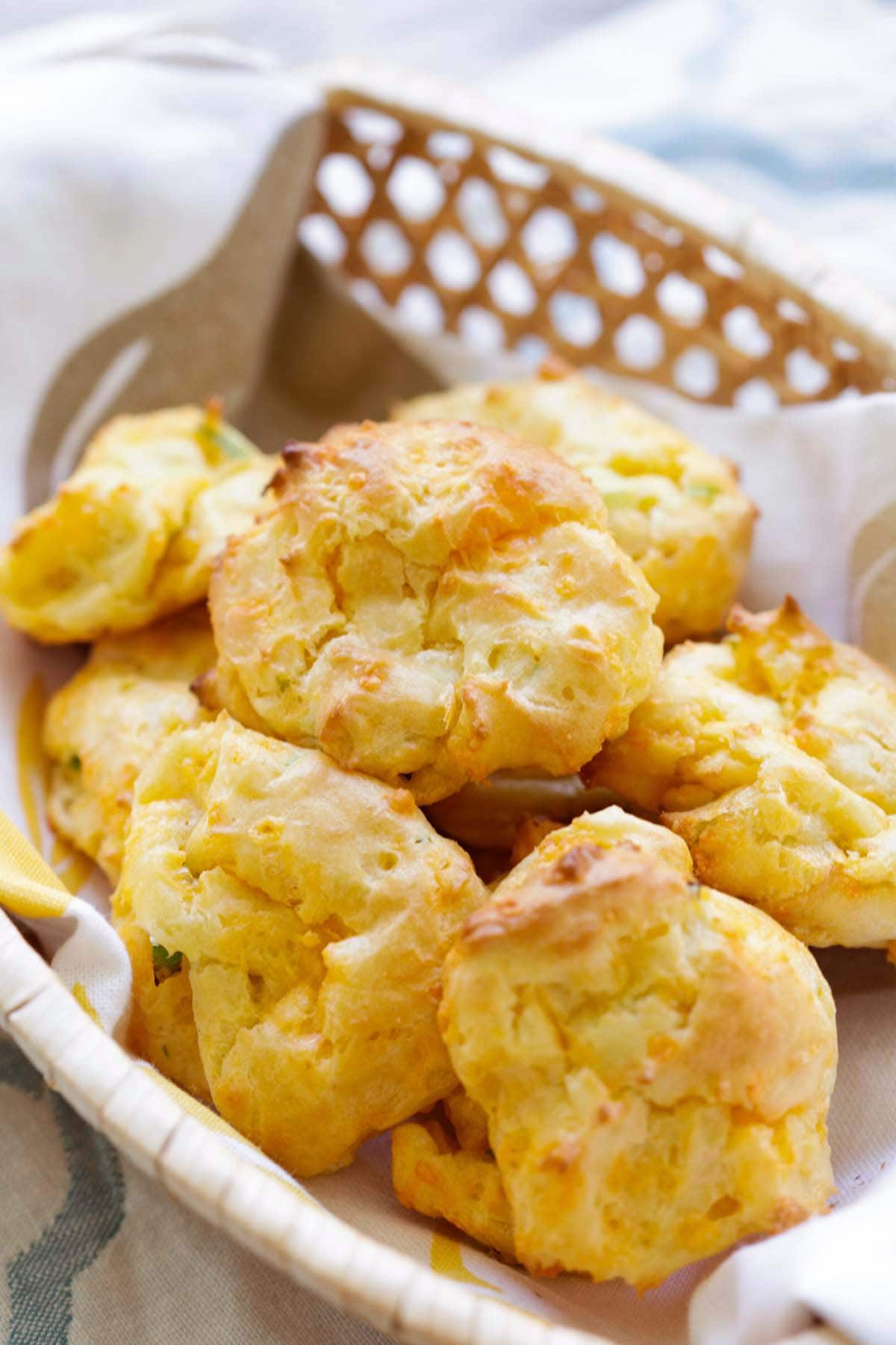 Cheesy fluffy golden brown puffs served in a basket.