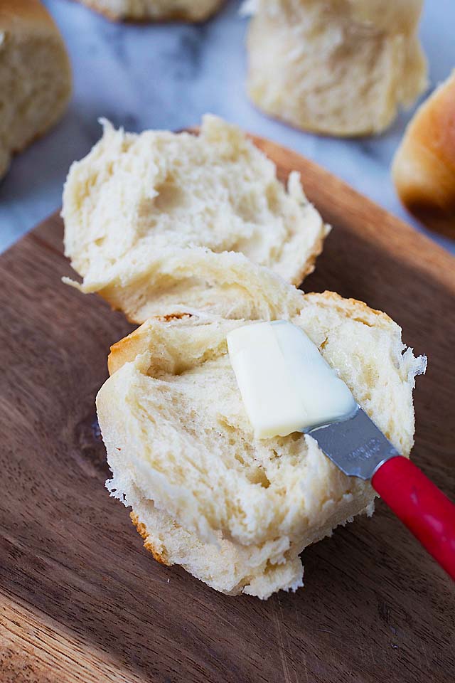 Spreading butter on a super soft homemade dinner roll.