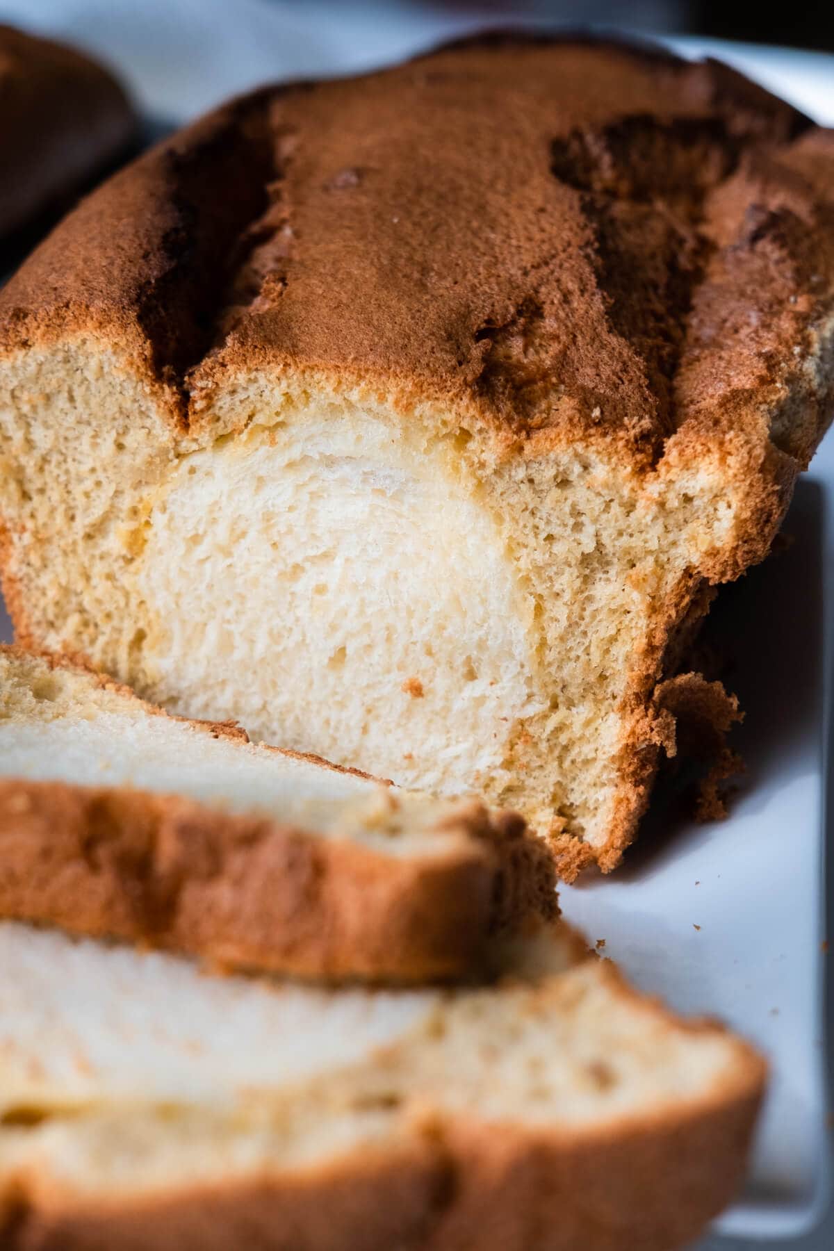 Closed up shot of a loaf of bread cake made with sweet white bread on the inside and coffee cake on the outside. 