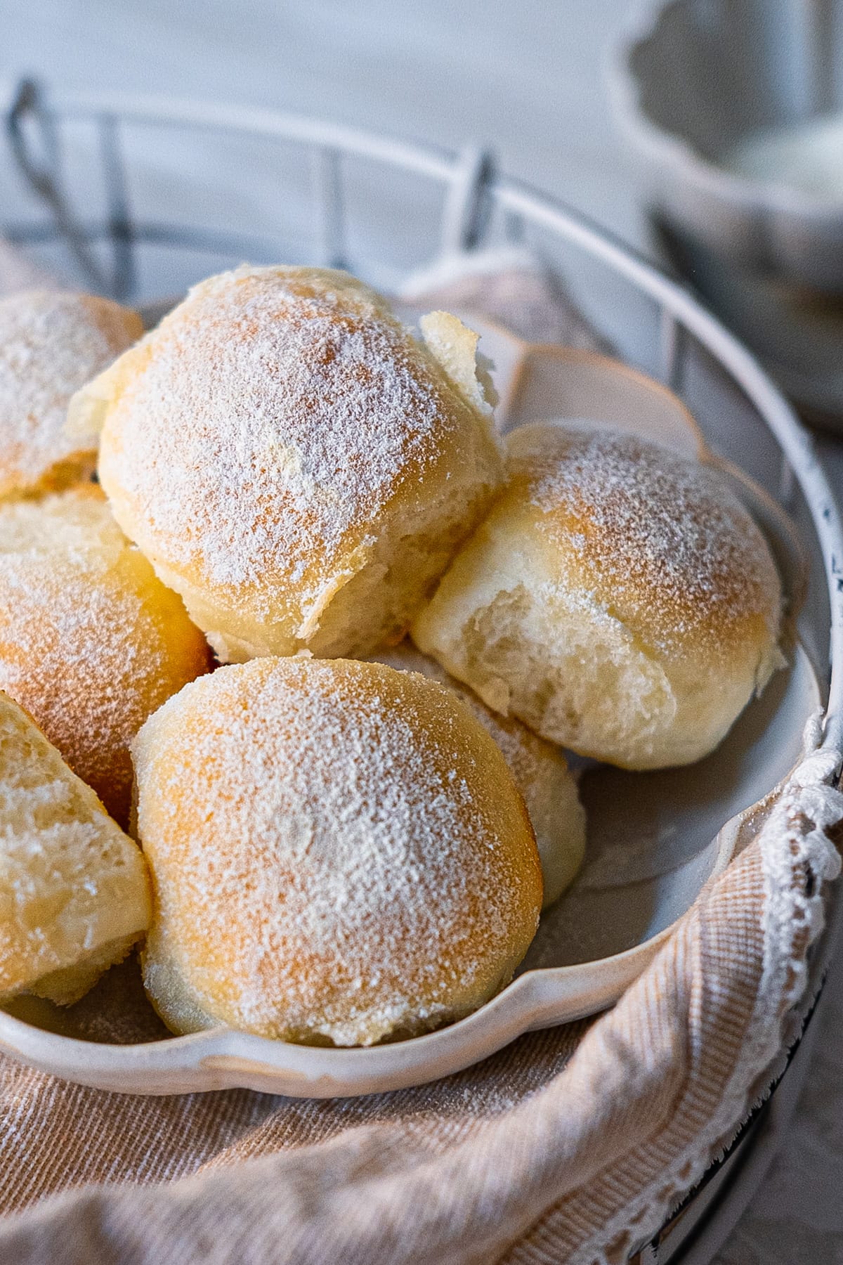 Golden-brown exterior and soft, fluffy texture milk buns in a bowl. 
