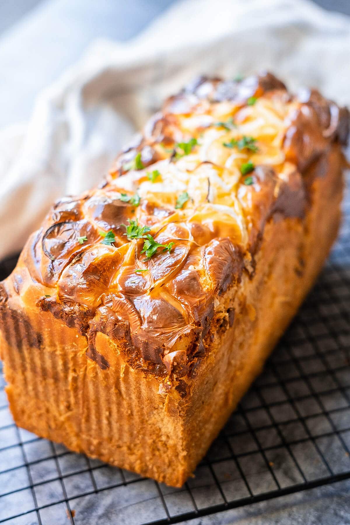 A ham and cheese loaf bread, showcasing a golden-brown crust and melted cheese on top. 