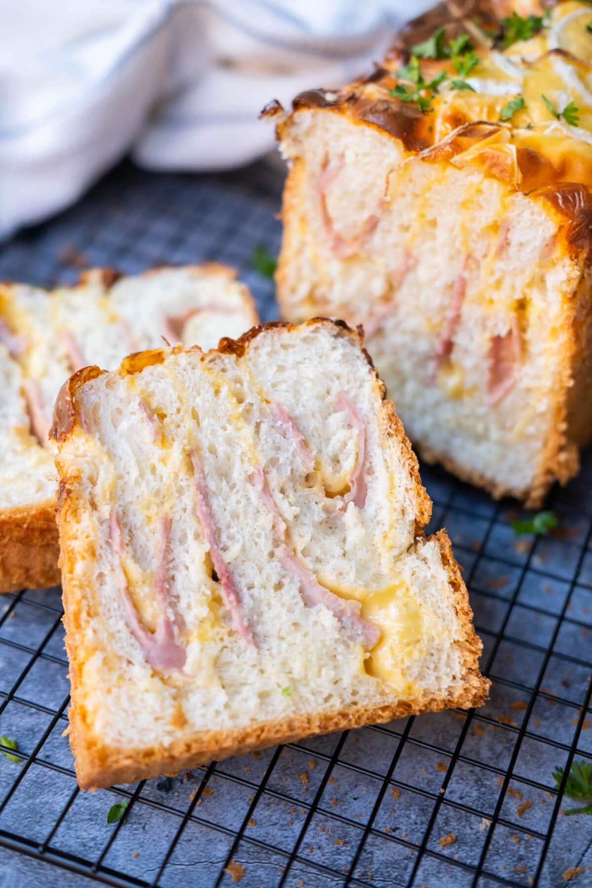 A piece of freshly baked ham and cheese bread with crispy crust and melted cheese on top. 