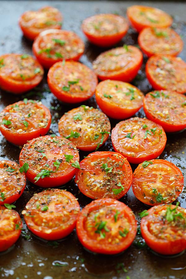 Easy and delicious herb oven-roasted tomatoes with Italian seasoning and herb, in a baking tray.