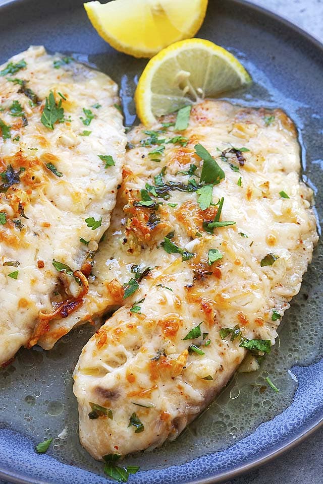Tilapia with lemon and Parmesan cheese on plate, ready to serve.