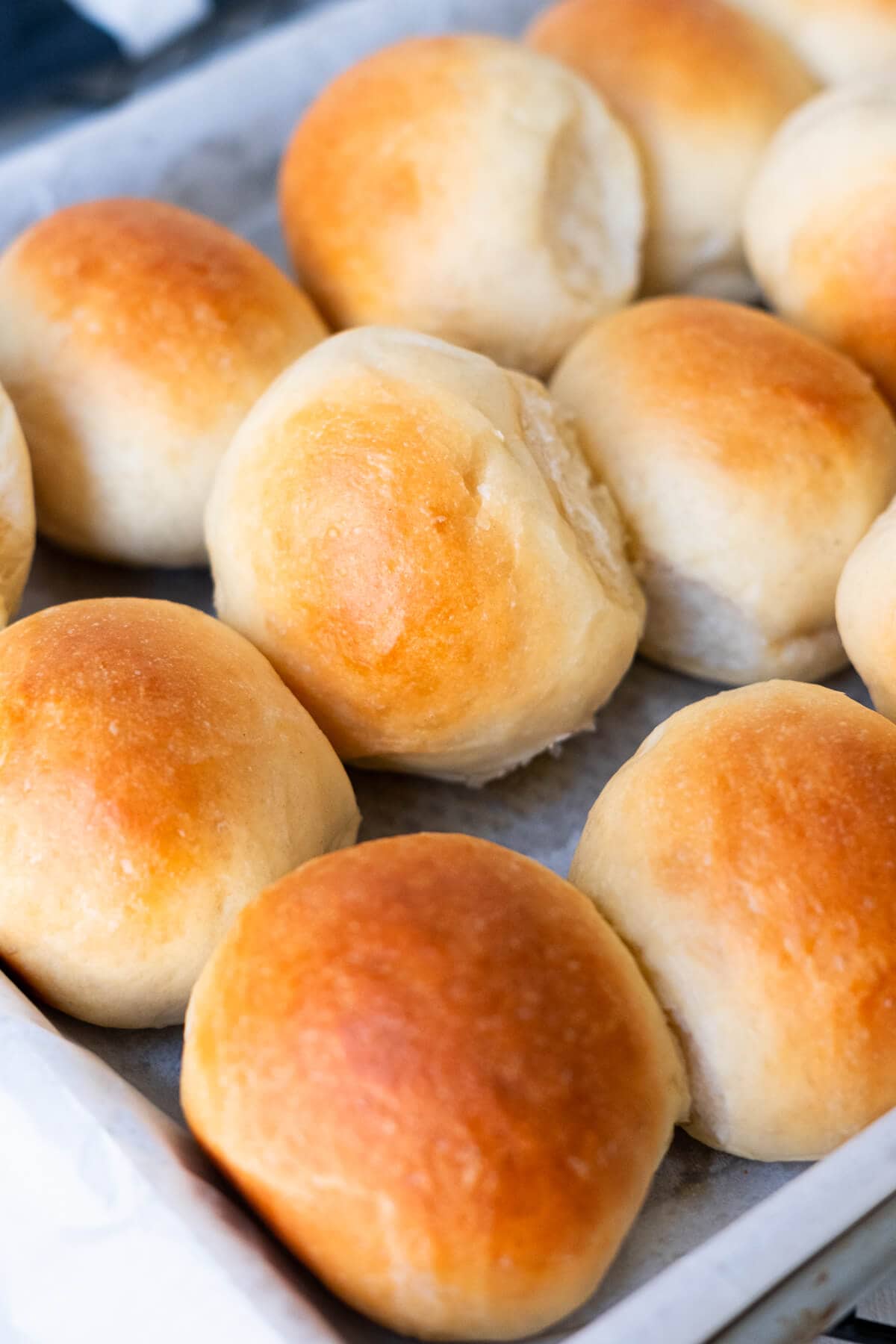 Golden fluffy brown slider buns in a baking pan.