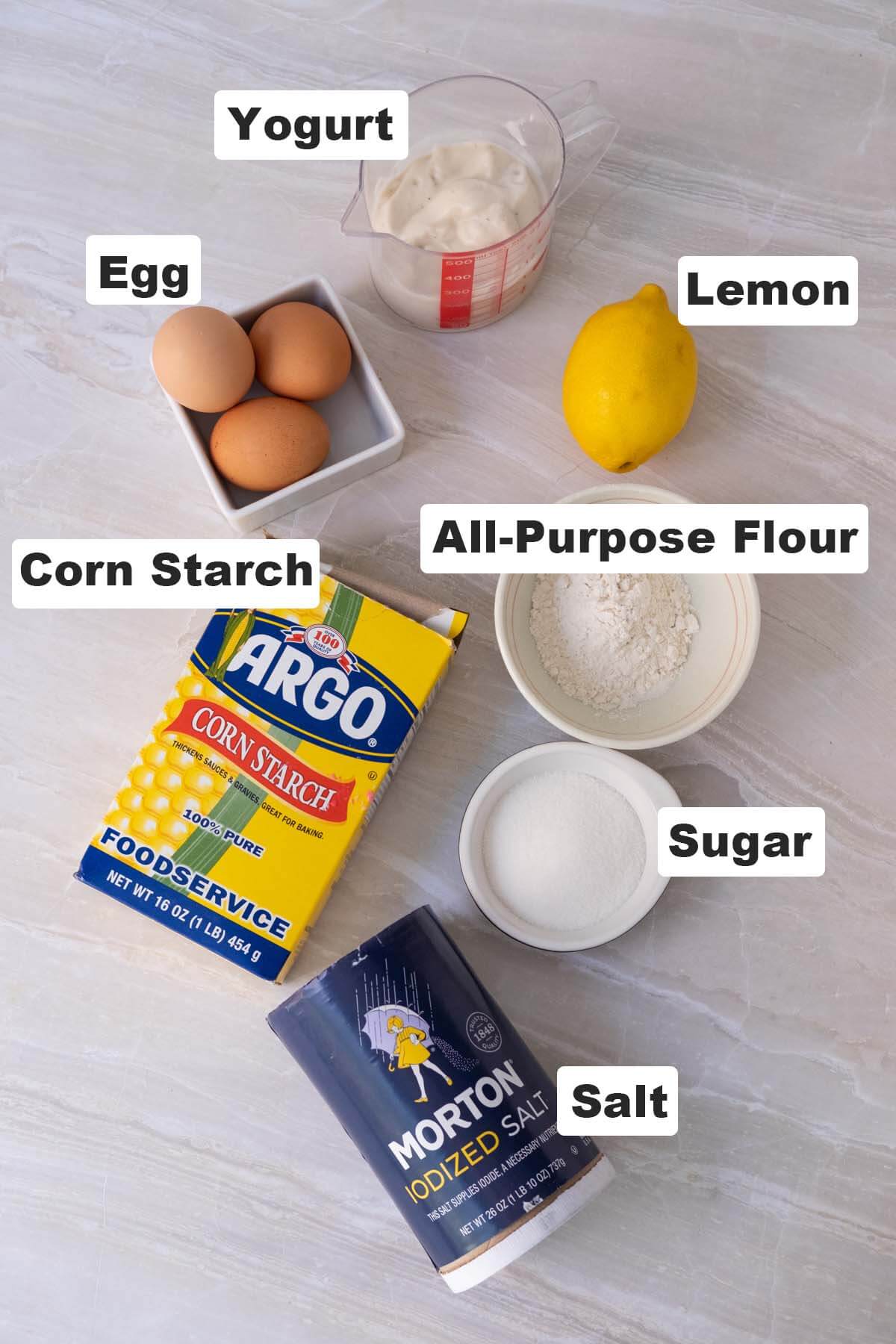 Ingredients for yogurt cake recipe: yogurt, egg, lemon, all-purpose flour, corn starch, salt and sugar. 